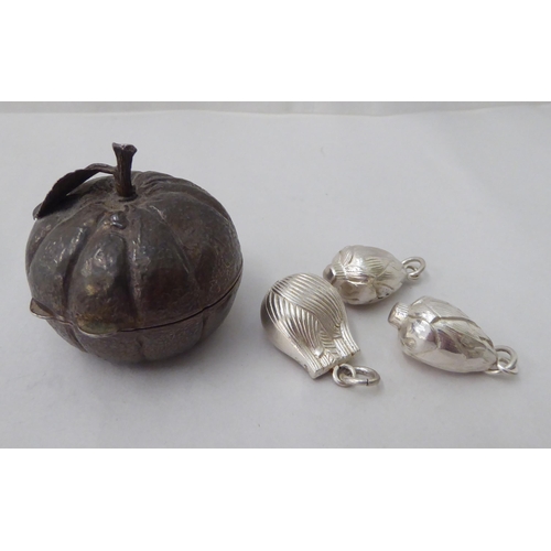 144 - A white metal fruit ornament and three pendants