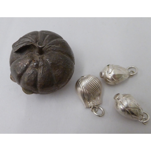 144 - A white metal fruit ornament and three pendants