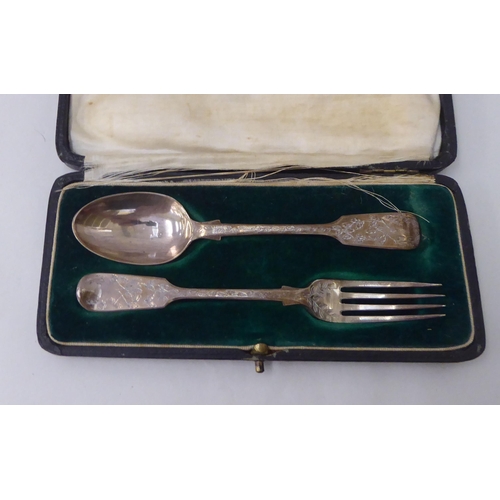 145 - A late Victorian two piece silver Christening presentation set, a spoon and fork, decorated with fol... 