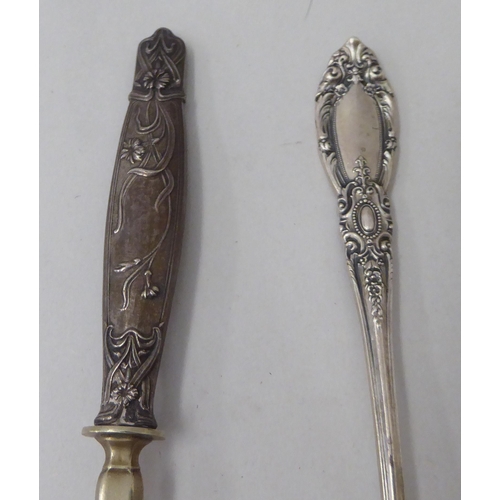 148 - Three items of white metal flatware: to include an Art Nouveau period spoon with a floral decorated ... 