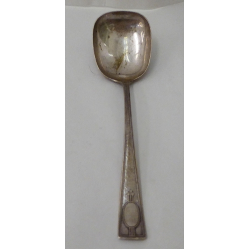 148 - Three items of white metal flatware: to include an Art Nouveau period spoon with a floral decorated ... 