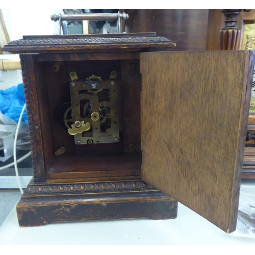 153 - An early 20thC walnut cased mantel clock; the 8 day movement faced by a Roman dial  19