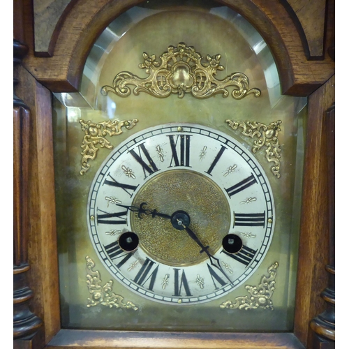 153 - An early 20thC walnut cased mantel clock; the 8 day movement faced by a Roman dial  19