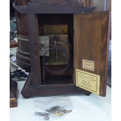 153 - An early 20thC walnut cased mantel clock; the 8 day movement faced by a Roman dial  19