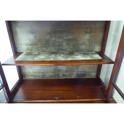 17 - An Edwardian crossbanded and ebony inlaid cabinet bookcase, the upper section with two glazed doors,... 