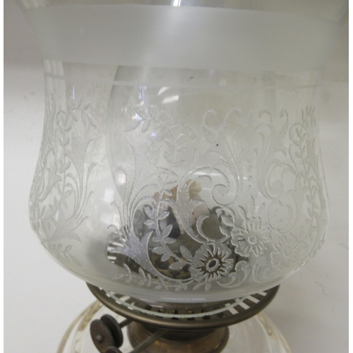 184 - A late Victorian clear glass oil lamp with a brass column and a black china plinth  19