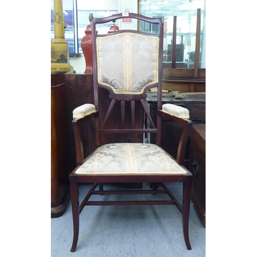 189 - An early 20thC mahogany framed side chair with a high back and open arms, upholstered in braided flo... 