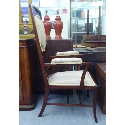 189 - An early 20thC mahogany framed side chair with a high back and open arms, upholstered in braided flo... 