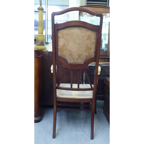 189 - An early 20thC mahogany framed side chair with a high back and open arms, upholstered in braided flo... 