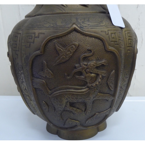 200 - A 20thC Chinese bronze vase, decorated in relief with spiraling dragons and animals  15