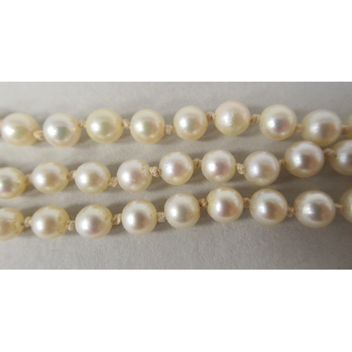 22 - A graduated three row pearl necklace, on a 9ct gold rosette clasp