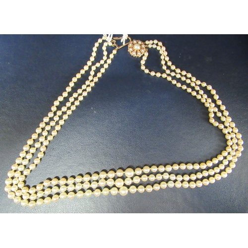 22 - A graduated three row pearl necklace, on a 9ct gold rosette clasp