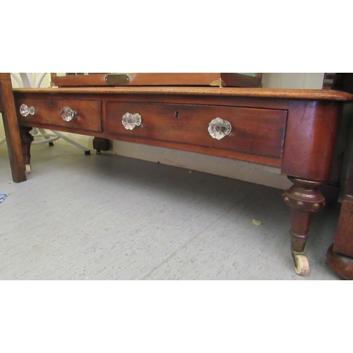 24 - A late Victorian mahogany three tier buffet with fret carved end supports and a base drawer, raised ... 