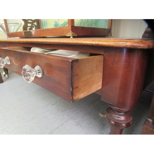 24 - A late Victorian mahogany three tier buffet with fret carved end supports and a base drawer, raised ... 