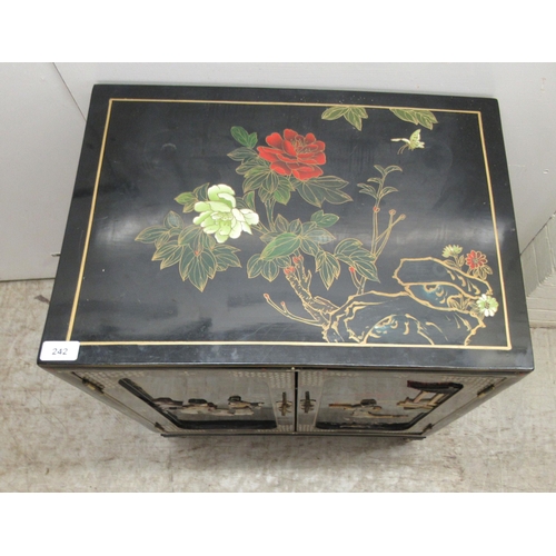 242 - A 20thC Japanese black lacquered and gilded side cabinet with a pair of panelled doors, raised on br... 