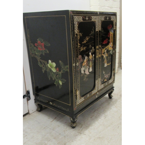 242 - A 20thC Japanese black lacquered and gilded side cabinet with a pair of panelled doors, raised on br... 