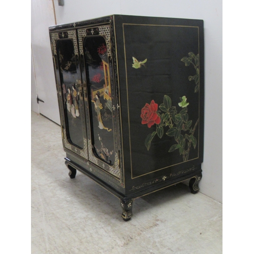 242 - A 20thC Japanese black lacquered and gilded side cabinet with a pair of panelled doors, raised on br... 