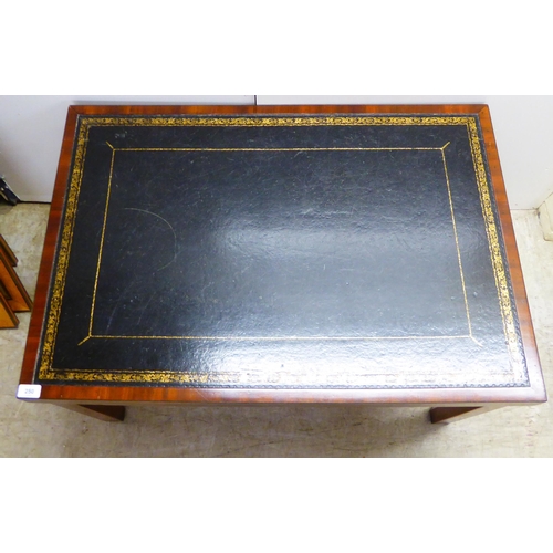 250 - A 20thC mahogany framed coffee table, the top set with a tooled and gilded hide scriber, raised on s... 