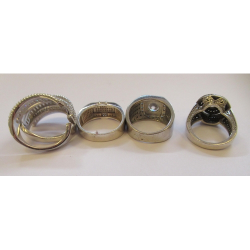 36 - Four dissimilar, silver coloured metal rings, variously set with cubic zirconia