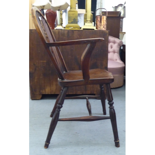 53 - A 19thC ash and elm framed Windsor low hoop, spindled wheelback chair, the open arms on crook suppor... 