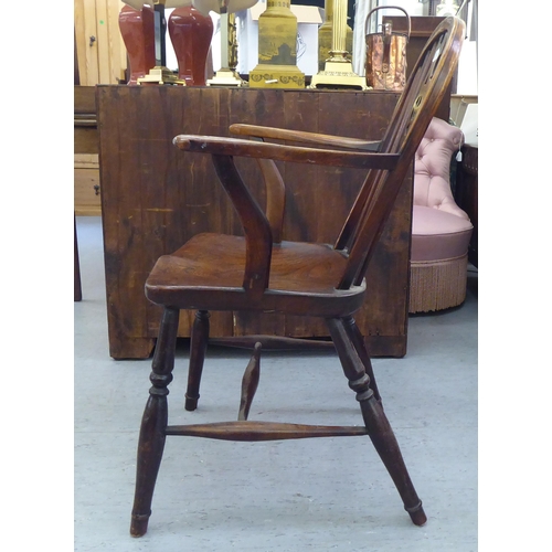 53 - A 19thC ash and elm framed Windsor low hoop, spindled wheelback chair, the open arms on crook suppor... 