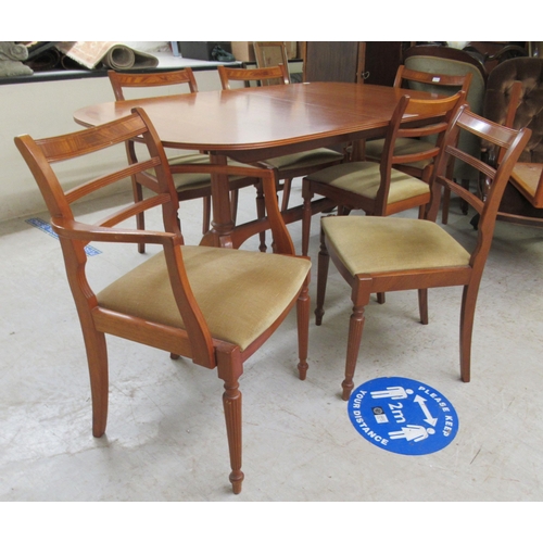 61 - A modern Regency style satin mahogany, oval dining table with a crossbanded top and an integral spar... 