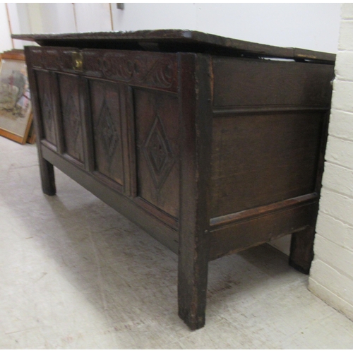 63 - An 18thC country made oak coffer with straight sides and a diamond carved, quadruple panelled front ... 