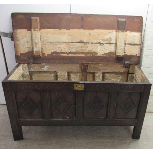 63 - An 18thC country made oak coffer with straight sides and a diamond carved, quadruple panelled front ... 