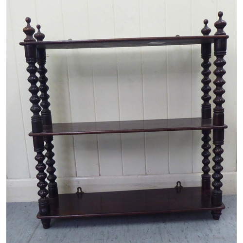 83 - A late Victorian mahogany three tier hanging shelf unit, on bobbin turned pillars  25