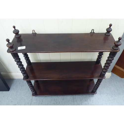 83 - A late Victorian mahogany three tier hanging shelf unit, on bobbin turned pillars  25