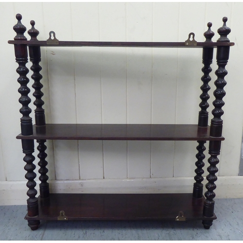 83 - A late Victorian mahogany three tier hanging shelf unit, on bobbin turned pillars  25