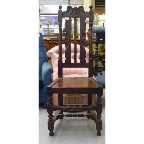 84 - A late 18thC fruitwood, beech and elm side chair, the high back with carved ornament between turned ... 