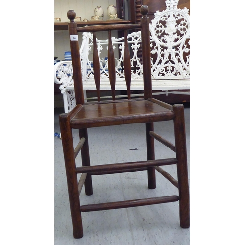 86 - A 19thC child's turned oak and elm framed chair with a triple, elliptical spindled back and hollow s... 