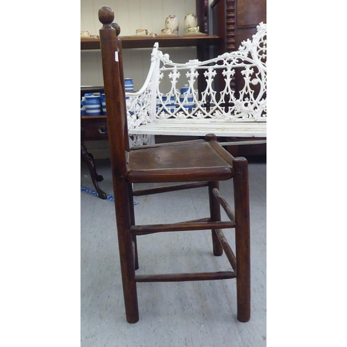 86 - A 19thC child's turned oak and elm framed chair with a triple, elliptical spindled back and hollow s... 