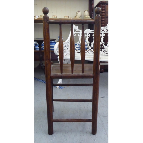 86 - A 19thC child's turned oak and elm framed chair with a triple, elliptical spindled back and hollow s... 