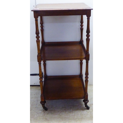 92 - An early 20thC oak three tier whatnot, on slender baluster supports, turned feet and cup casters  36... 