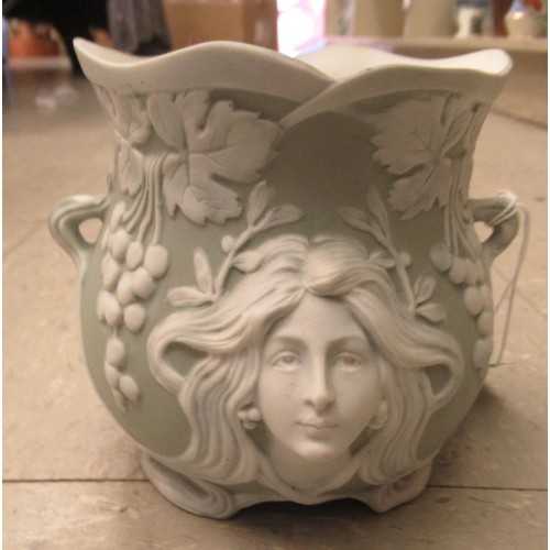 186 - An early 20thC Continental Art Nouveau porcelain pot, decorated in relief with mask motifs and grape... 