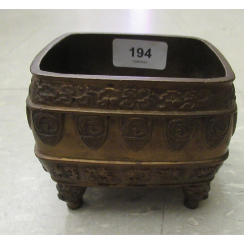 194 - An early 20thC Chinese bronze censer, cast with animal and cloud motifs, on mask feet  3.5