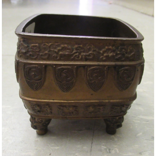 194 - An early 20thC Chinese bronze censer, cast with animal and cloud motifs, on mask feet  3.5