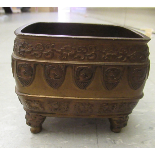 194 - An early 20thC Chinese bronze censer, cast with animal and cloud motifs, on mask feet  3.5