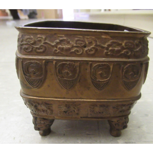 194 - An early 20thC Chinese bronze censer, cast with animal and cloud motifs, on mask feet  3.5