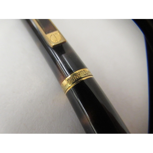 136 - A Dunhill ballpoint pen with a turning roller, gold plating and tortoiseshell effect ccasing  c... 