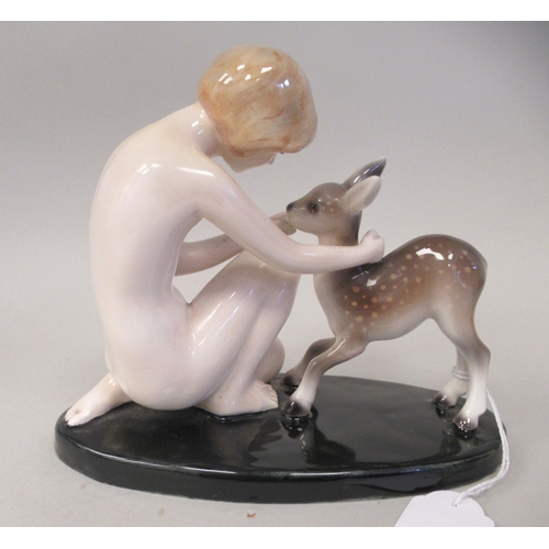 128 - An Art Deco Goldscheider, Claire Weiss porcelain group, a girl kneeling with a fawn, on an oval base... 