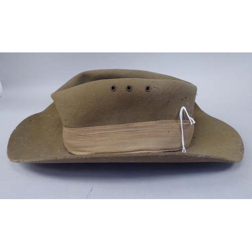 147 - A 1943 dated khaki felt hat with a woven cloth parachute badge (Please Note: this lot is subject to ... 