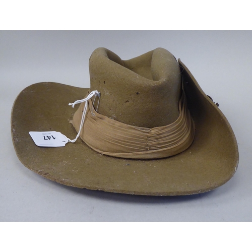 147 - A 1943 dated khaki felt hat with a woven cloth parachute badge (Please Note: this lot is subject to ... 