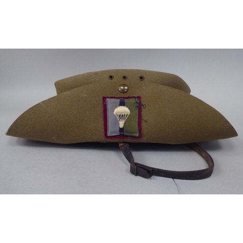 147 - A 1943 dated khaki felt hat with a woven cloth parachute badge (Please Note: this lot is subject to ... 