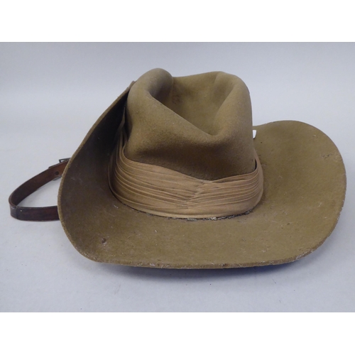 147 - A 1943 dated khaki felt hat with a woven cloth parachute badge (Please Note: this lot is subject to ... 