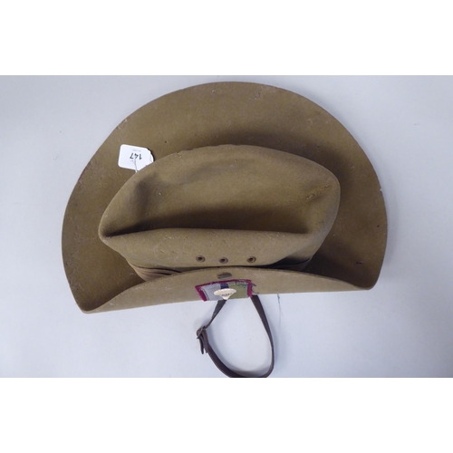 147 - A 1943 dated khaki felt hat with a woven cloth parachute badge (Please Note: this lot is subject to ... 