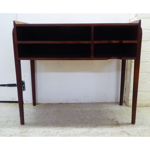 28 - A 1960s Danish rosewood side table with a low galleried top, over two enclosed shallow shelves, rais... 