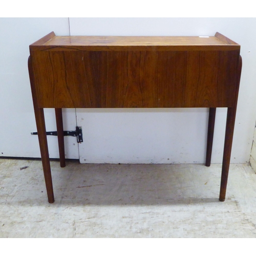 28 - A 1960s Danish rosewood side table with a low galleried top, over two enclosed shallow shelves, rais... 